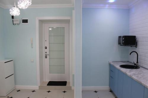La salle de bains est pourvue d'un lavabo et d'un miroir. dans l'établissement Двухкомнатная квартира в центре города, à Uralsk