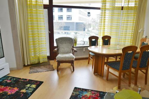 d'un salon avec une table, des chaises et une fenêtre. dans l'établissement Grömitz-Center Whg 204, à Grömitz