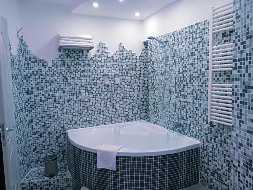 een badkamer met een bad in een betegelde douche bij BORGO LORETO NAPLES in Napels