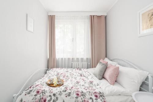 a bedroom with a bed with a plate of food on it at Apartment Floriana Stablewskiego Poznań by Renters in Poznań