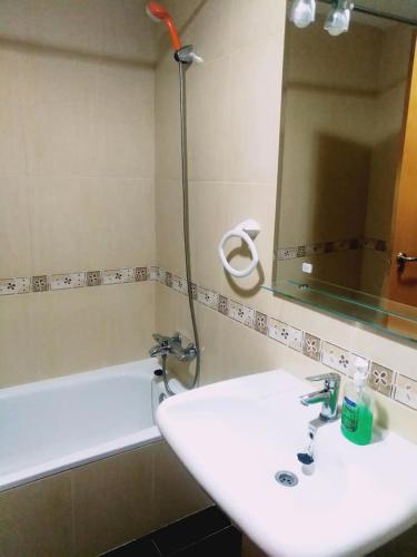a bathroom with a sink and a mirror and a tub at Chulillagreenhouse in Chulilla