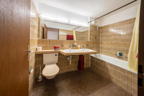 ein Badezimmer mit einem WC, einem Waschbecken und einer Badewanne in der Unterkunft Chasa Plavna in Vulpera