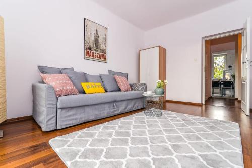 a living room with a gray couch and a rug at Rent like home - Świętokrzyska 32 in Warsaw