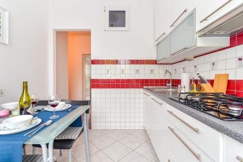 a kitchen with white cabinets and a table with wine glasses at Rent like home - Świętokrzyska 32 in Warsaw