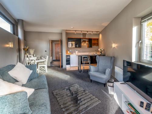 a living room with a couch and a dining room at Modern flat a short walk from Shrewsbury centre - Pass the Keys in Shrewsbury