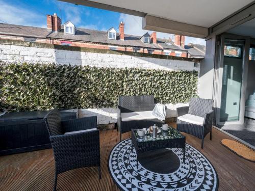 a patio with chairs and a table on a deck at Modern flat a short walk from Shrewsbury centre - Pass the Keys in Shrewsbury