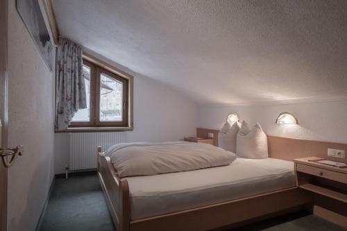 a small bedroom with a bed and a window at Huber Apartments in Kappl