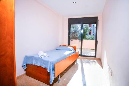 ein kleines Schlafzimmer mit einem Bett mit einer blauen Decke in der Unterkunft Apartment Equipped With Sea Views in Lloret de Mar