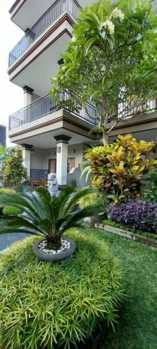 a garden in front of a building with a plant at Umayuri Inn in Ubud