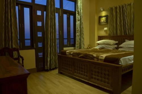 Un dormitorio con una cama grande y una ventana en Ganga Monastery, en Varanasi