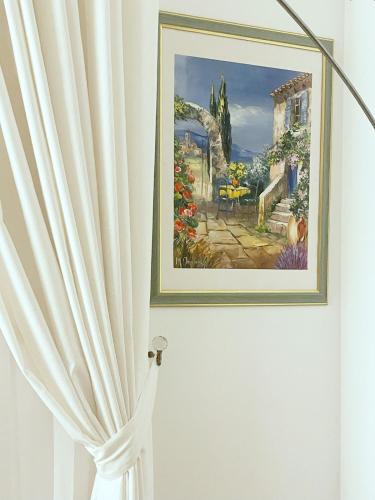 a painting hanging on a wall next to a curtain at Place Sainte Marguerite in Provins