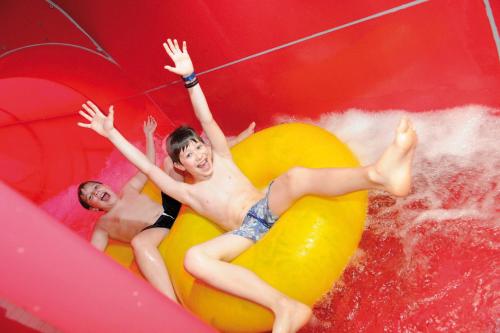 two young men are riding on an inflatable at Courtyard by Marriott Basel in Pratteln
