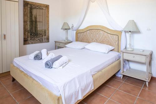 a bedroom with a white bed with towels on it at Elysium Paros Houses in Chrissi Akti