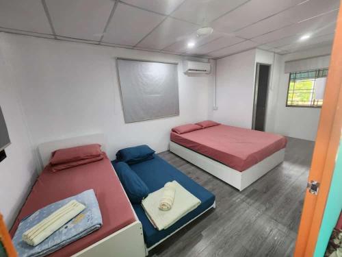 Simpang EmpatにあるHomestay Denai Harummanis S4のベッド2台と壁にチョークボードが備わる客室です。