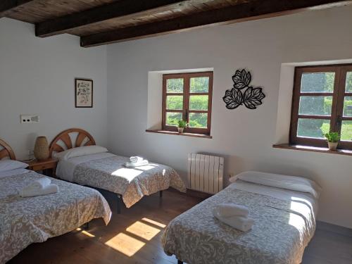 pokój z 3 łóżkami i 2 oknami w obiekcie Apartamento de la Marmota w mieście Eriste