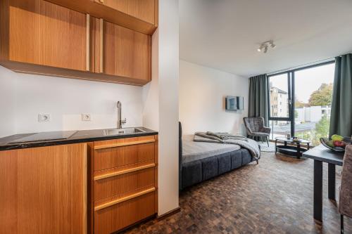 ein Hotelzimmer mit einem Bett und einem Waschbecken sowie einer Küche in der Unterkunft Baker`s Home in Augsburg