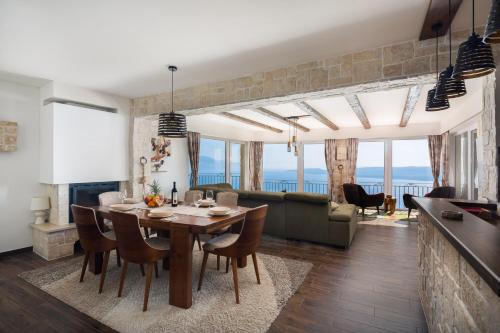 a dining room and living room with a table and chairs at Holiday Home La Montagna - Private Heated Pool in Lokva Rogoznica