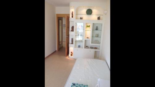 Zimmer mit einer weißen Wand und einem Regal in der Unterkunft Modern Penthouse-duplex Facing The Sea in La Torre
