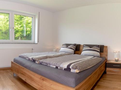 ein großes Bett in einem Zimmer mit Fenster in der Unterkunft Hof am Horn - Fewos in der Natur in Laichingen