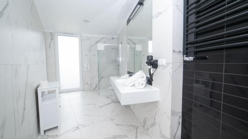 a white bathroom with a sink and a mirror at Apartament Bellavue w Czarnej Perle in Stronie Śląskie