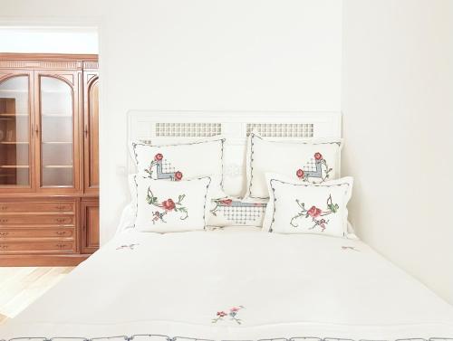 a white bedroom with a white bed with pillows at Place Sainte Marguerite in Provins