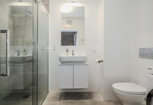 een witte badkamer met een wastafel en een toilet bij Platinium Dwie Motławy River View in Gdańsk