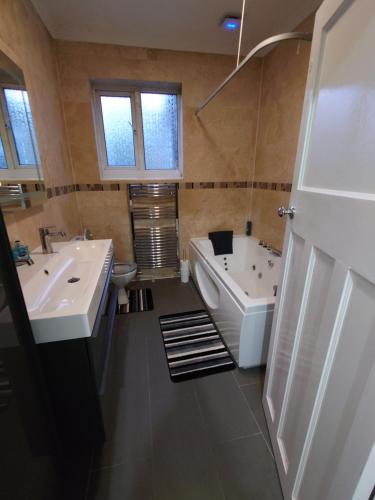 a bathroom with two sinks and a tub and a toilet at Edwardian 5 bedroom townhouse, next to underground in London