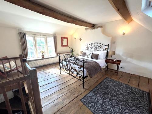 um quarto com uma cama e piso em madeira em Bath Road Holiday em Bradford on Avon
