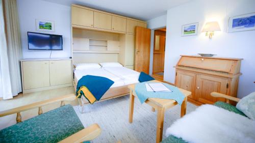 1 dormitorio con 1 cama, TV y sofá en Faltenbach Ferienwohnungen in Oberstdorf, en Oberstdorf