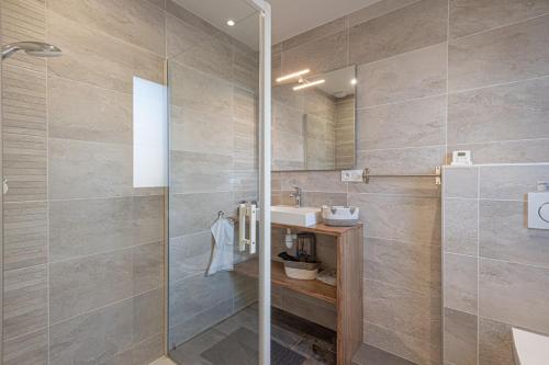 uma casa de banho com um chuveiro e um lavatório. em Gites de Téno Bras - L'Océan em Plouharnel