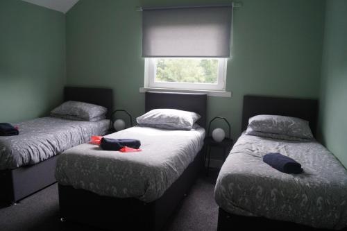 two twin beds in a room with a window at Garnock 3 in Beith