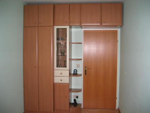 Zimmer mit einem Holzschrank und einer Tür in der Unterkunft Wien Purkersdorf in Purkersdorf