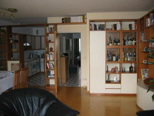 a living room with wooden shelves and a kitchen at Wien Purkersdorf in Purkersdorf