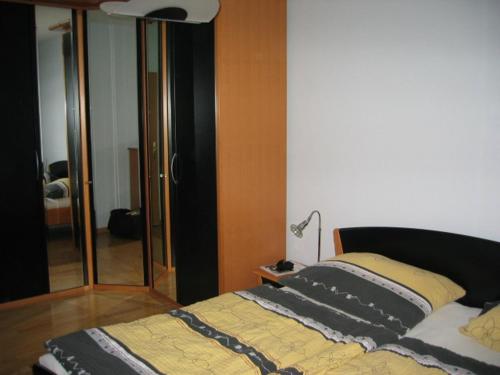ein Schlafzimmer mit einem Bett, einer Lampe und einem Spiegel in der Unterkunft Wien Purkersdorf in Purkersdorf