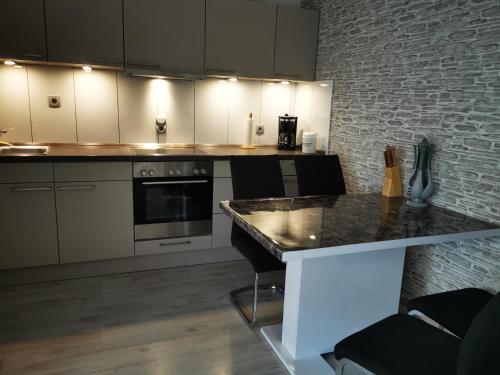 a kitchen with white cabinets and a black counter top at Haus Mila in Freudenstadt