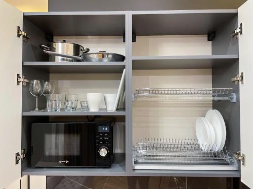 a kitchen with a microwave and some dishes at LUX Апартаменти MYFREEDOM поруч метро Театральна, Хрещатик in Kyiv