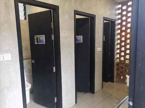 drie zwarte deuren in een badkamer met toilet bij Belle Vue 408 Genting View Resort in Genting Highlands