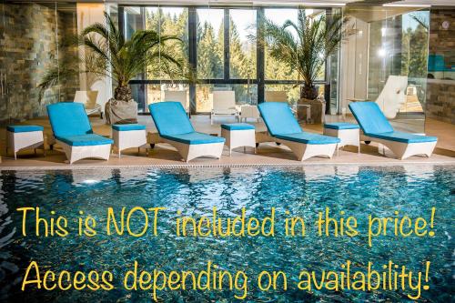 a swimming pool with blue chairs next to a swimming pool at Floriday Luxury Apartment in Silver Mountain in Poiana Brasov