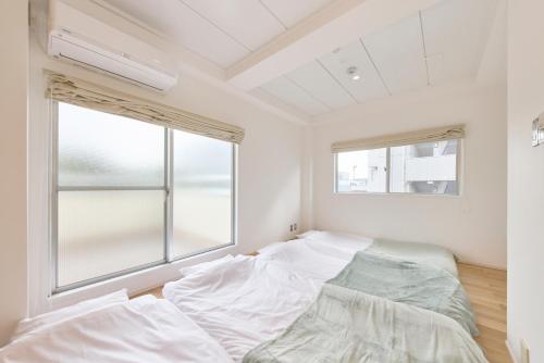 - une chambre avec 2 lits et une fenêtre dans l'établissement BANBOO HOUSE, à Osaka