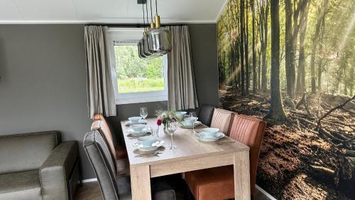 a dining room with a table and chairs and a window at Waterpark Giethoorn in Giethoorn