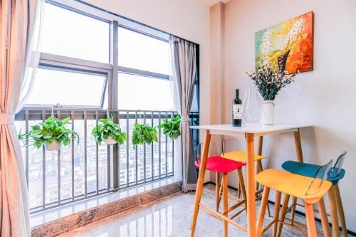 um quarto com uma mesa e cadeiras e uma varanda em B T Miele Executive Apartment - Shenzhen Wanda Plaza em Bao'an