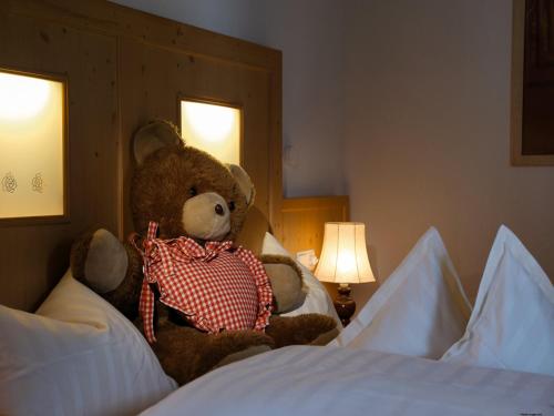 a teddy bear sitting on top of a bed at Boutique Hotel Haidachhof superior in Fügen
