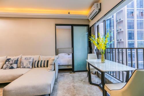 uma sala de estar com um sofá e uma mesa em B T Miele Executive Apartment - Shenzhen Wanda Plaza em Bao'an