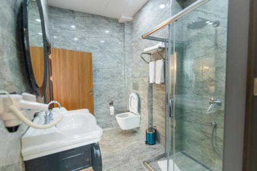 a bathroom with a shower and a sink and a toilet at Fevzi Hoca Butik Hotel in Trabzon