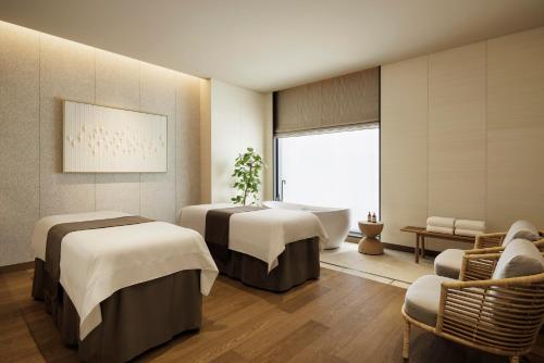 a spa room with three beds and a bathtub at Sheraton Kagoshima in Kagoshima