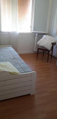 une chambre avec un lit, une chaise et une fenêtre dans l'établissement Joli appartement vue sur mer, à Cannes