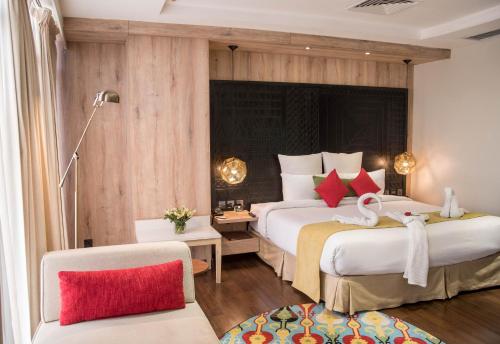 una camera d'albergo con due letti e una sedia di HOTEL dGATES a Lahore