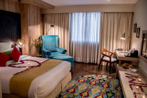 a hotel room with a bed and a blue chair at HOTEL dGATES in Lahore