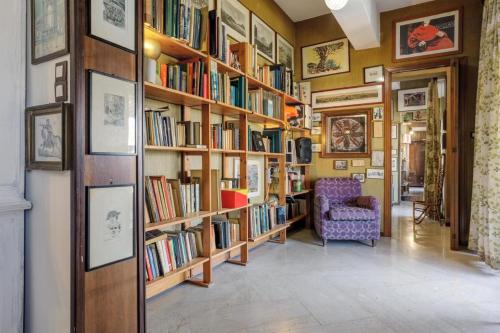 uma biblioteca com prateleiras de madeira cheias de livros em Artists penthouse em Palermo