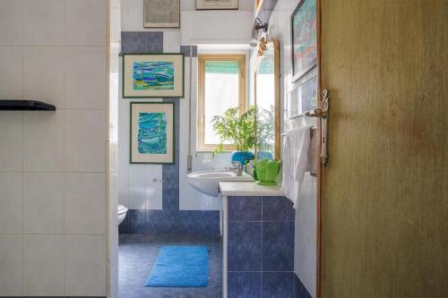 uma casa de banho com um lavatório, um WC e uma janela. em Artists penthouse em Palermo